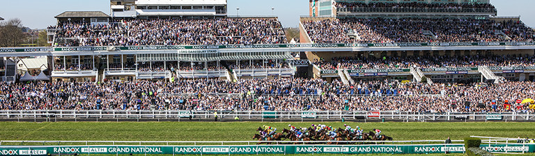 Horse racing finishing post scene with grandstand background